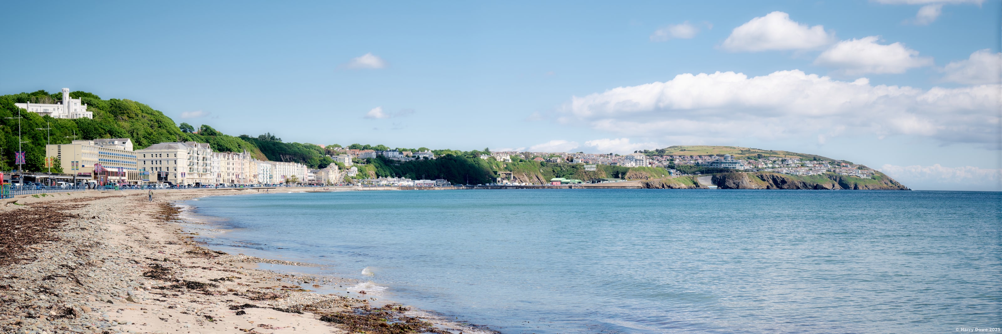 An expansive panorama across a beach under clear skies.