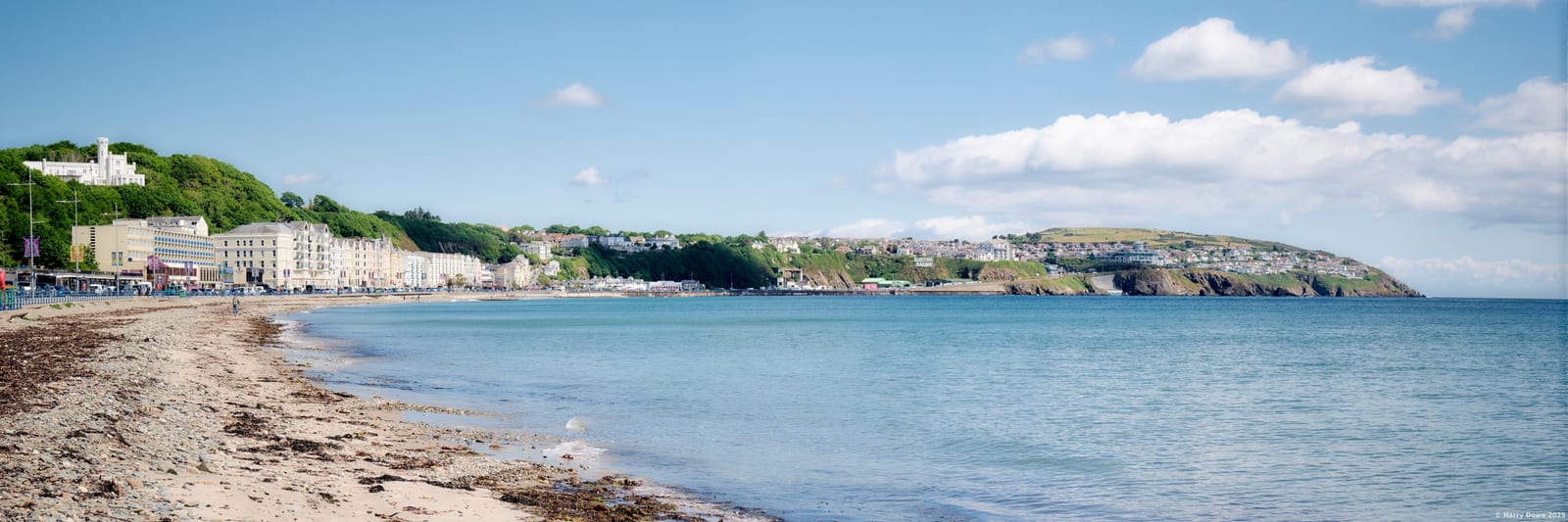 An expansive panorama across a beach under clear skies.